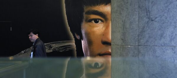 Čovek prolazi pored postera za Brus Lijevu izložbu u Hong Kongu. Čovek prolazi pored postera za Brus Lijevu izložbu u Hong Kongu. - Sputnik Srbija