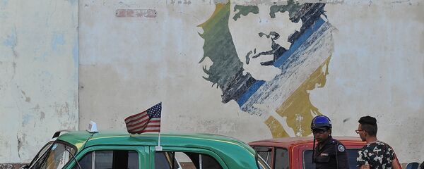 Automobil prolazi pored grafita sa likom Ernesta Če Gevare u Havani na Kubi - Sputnik Srbija