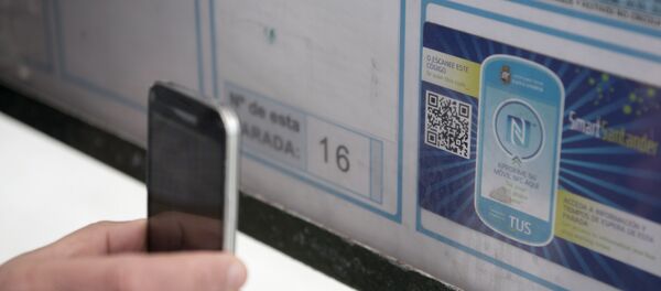 Čovek koristi mobilni telefon da bi očitao kod za pametnu nalepnicu na autobuskom stajalištu u Santanderu. Pametna nalepnica pruža informacije o redu vožnje gradskog prevoza Čovek koristi mobilni telefon da bi očitao kod za pametnu nalepnicu na autobuskom stajalištu u Santanderu. Pametna nalepnica pruža informacije o redu vožnje gradskog prevoza - Sputnik Srbija