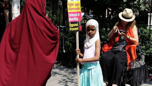 Devojčica sa tranparentom ispred Džamije u Londonu gde se desio napad na muslimanske vernike. - Sputnik Srbija