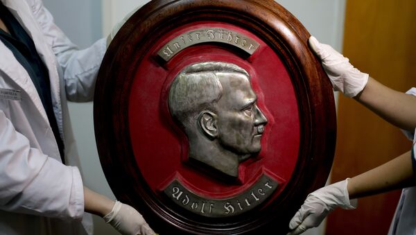 Federalni policajci pokazuju portret Adolfa Hitlera u sedištu Interpola u Buenos Ajresu. - Sputnik Srbija