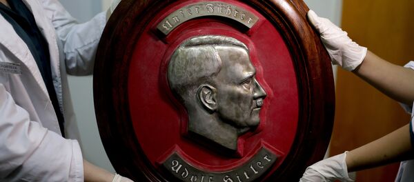 Federalni policajci pokazuju portret Adolfa Hitlera u sedištu Interpola u Buenos Ajresu. - Sputnik Srbija