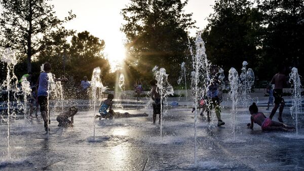 Деца се играју у фонтани у Атини током екстремних врућина у Грчкој - Sputnik Србија