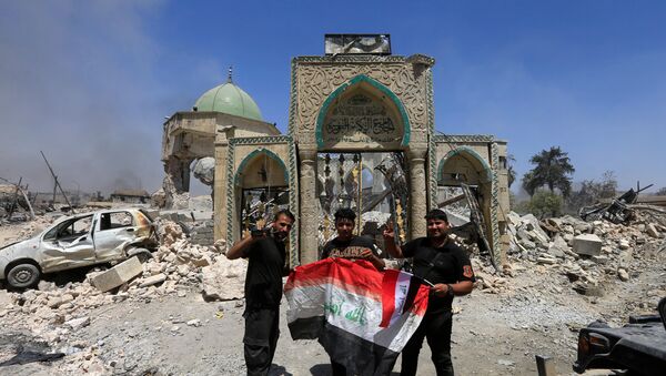 Припадници ирачких противтерористичких снага са заставом Ирака испред рушевина велике џамије Нури у Мосулу - Sputnik Србија