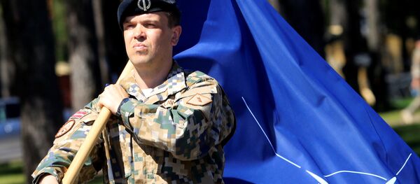 Letonski vojnik sa zastavom NATO-a Letonski vojnik sa zastavom NATO-a - Sputnik Srbija
