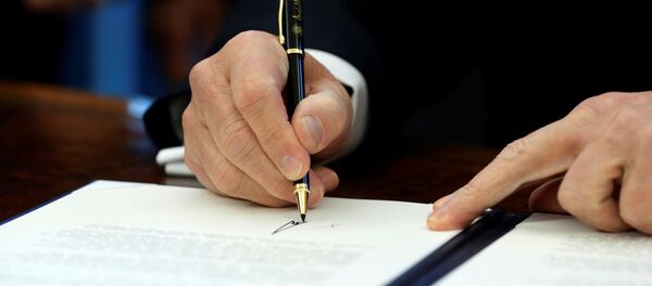 Амерички председник Доналд Трамп потписује документа у Овалном кабинету - Sputnik Србија