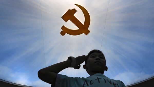 Dečak salutira logou Komunističke partije Kine - Sputnik Srbija