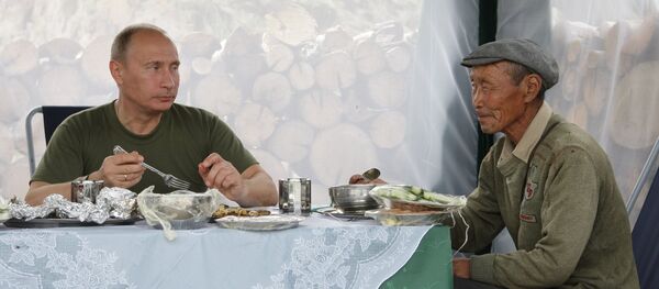 Владимир Путин на одмору пије чај са мештанином села у Туви. - Sputnik Србија
