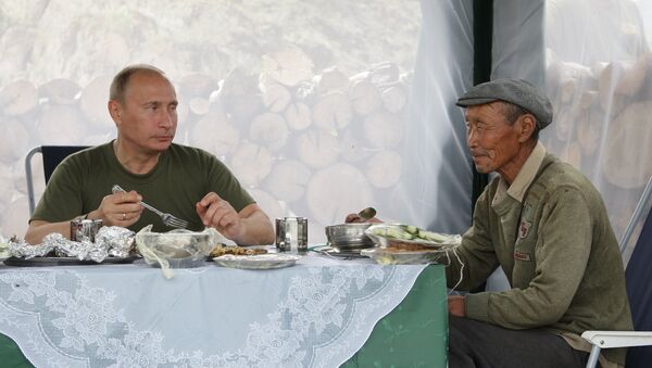 Владимир Путин на одмору пије чај са мештанином села у Туви. - Sputnik Србија