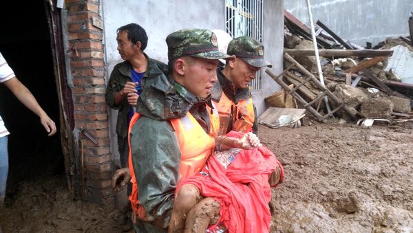 Spasioci iznose preživele nakon klizišta koje je uzrokovala kiša u kineskoj provinciji Sičuan - Sputnik Srbija
