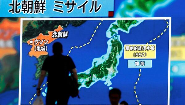 Čovek u Tokiju ispred javnog monitora na kom se prikazuju vesti o probnom ispaljivanju interkontinentalne balističke rekate Severne Koreje - Sputnik Srbija