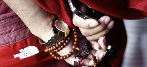 Рука тибетанског монаха са сатом, бројаницом и ајфоном - Sputnik Србија