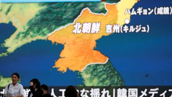 Људи у Токију пролазе поред монитора са вестима о нуклеарној проби Северне Кореје - Sputnik Србија