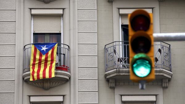 An estelada flag (Catalan separatist flag) hangs from a balcony, next to a green traffic light, in Barcelona, Spain, October 27, 2015 - Sputnik Србија