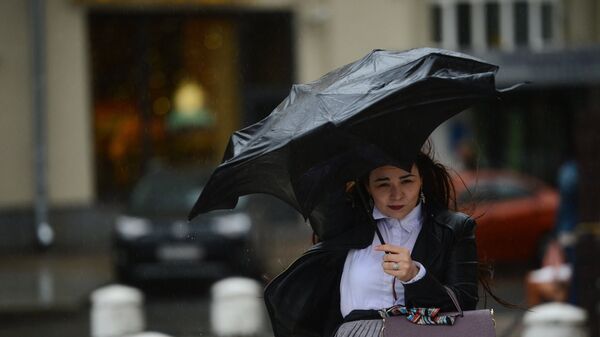 Devojka se štiti kišobranom tokom kiše u Moskvi - Sputnik Srbija