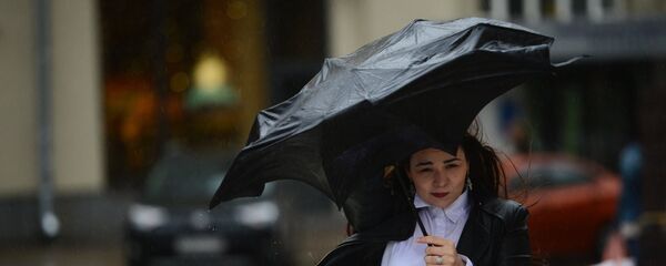Девојка се штити кишобраном током кише у Москви - Sputnik Србија