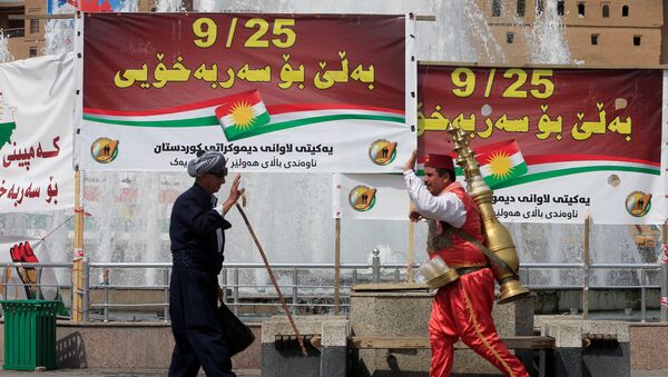 Ljudi prolaze pored reklama za referendum za nezavisnost Iračkog Kurdistana u Erbilu - Sputnik Srbija