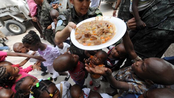 Brazilski mirovnjaci UN dele hranu siročićima na Haitiju. - Sputnik Srbija