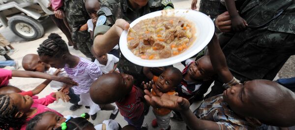 Brazilski mirovnjaci UN dele hranu siročićima na Haitiju. - Sputnik Srbija