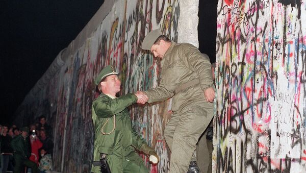 Rukovanje policajaca iz Istične i Zapadne Nemačke posle rušenja Berlinskog zida 12. novembra 1989.  - Sputnik Srbija