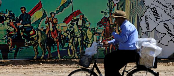 Бициклиста поред мурала у част курдског референдума о независности у Ираку. - Sputnik Србија