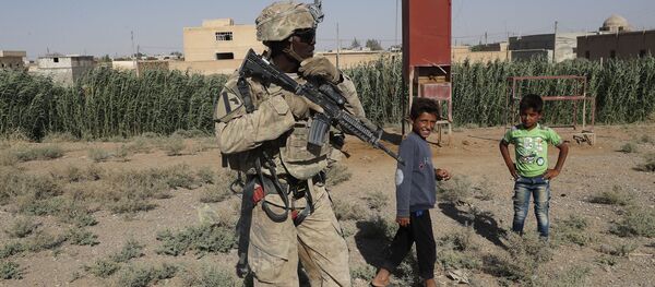 Američki vojnik stoji pored sirijske dece na putu za Raku - Sputnik Srbija