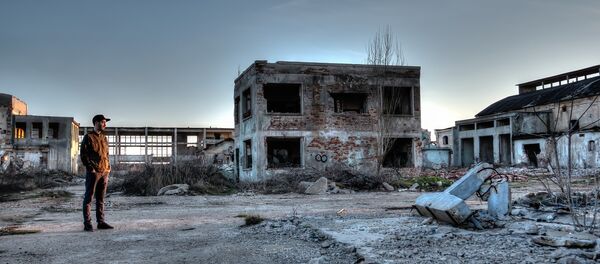 Čovek u uništenoj fabrici. - Sputnik Srbija