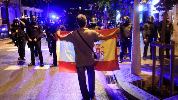 Присталица уједињења са заставом Шпаније стоји испред каталонске регионалне полиције у Барселони - Sputnik Србија