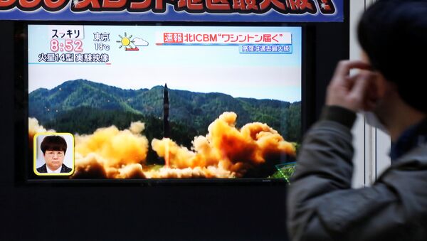 Čovek u Tokiju gleda televizijski izveštaj raketne probe Severne Koreje - Sputnik Srbija