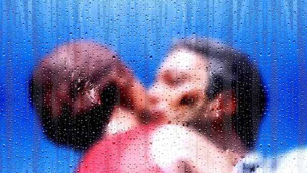 Muškarac i žena ljube se dok kiša pada na prozor - Sputnik Srbija
