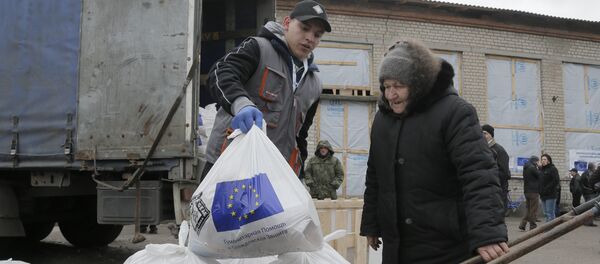 Žena prima humanitarnu pomoć EU u Semjonovki u Istočnoj Ukrajini - Sputnik Srbija