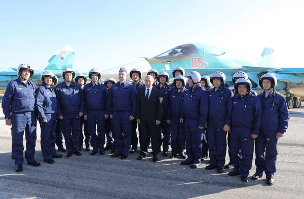 Председник Русије Владимир Путин са пилотима у војној бази Хмејмим у Сирији Председник Русије Владимир Путин са пилотима у војној бази Хмејмим у Сирији - Sputnik Србија