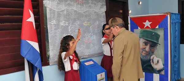 Председник Кубе Раул Кастро гласа на локалним изборима у Хавани, испред фотографије његовог брата, Фидела Кастра 26. новембра 2017. - Sputnik Србија