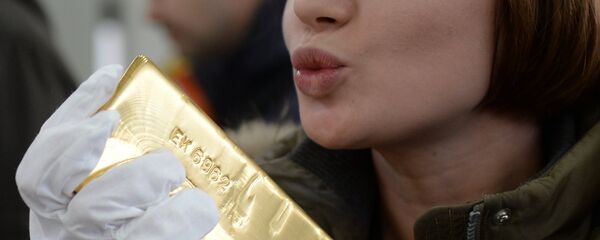 Девојка држи у руци златну полугу - Sputnik Србија