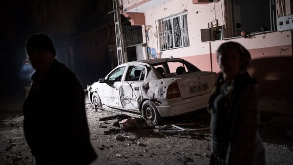 Ljudi stoje ispred zgrade koju je pogodila raketa ispaljena iz Sirije u turskom pograničnom gradu Kilis - Sputnik Srbija