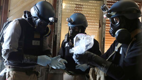 Stručnjaci za hemijsko oružje sa gas-maskama sakupljaju uzorke sa mesta navodnog hemijskog napada u predgrađu Damaska - Sputnik Srbija