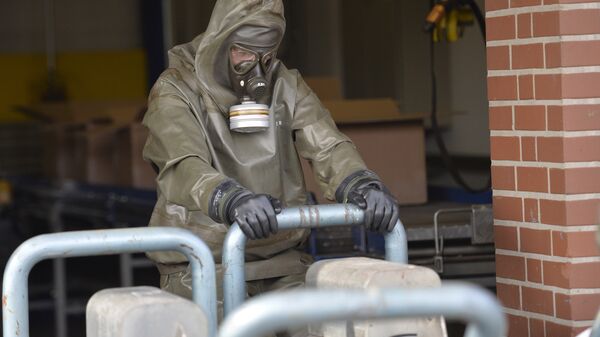 Стручњак за хемијско оружје са гас-маском сакупља узорке са места наводног хемијског напада - Sputnik Србија
