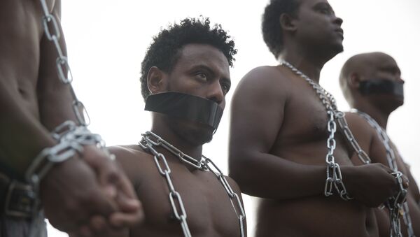 Мигранти из Еритреје носе ланце имитирајући робове на протесту против политике израелске владе испред Кнесета. - Sputnik Србија