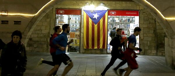 Људи трче поред заставе Каталоније - Sputnik Србија