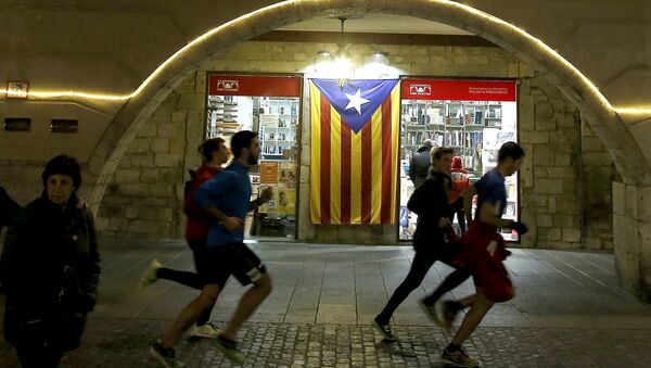 Људи трче поред заставе Каталоније - Sputnik Србија