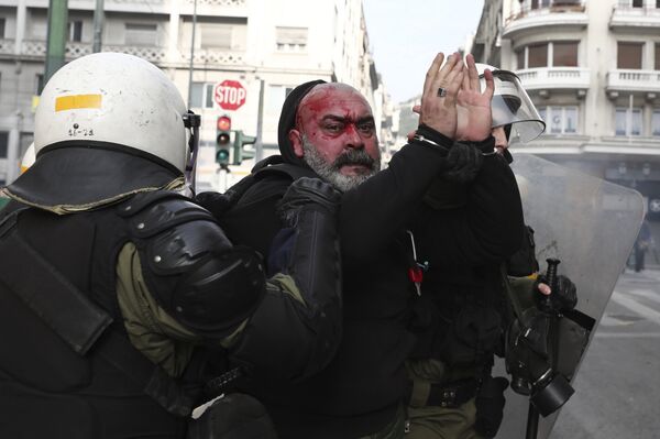 Полицајци хапсе демонстранта током протеста у Атини. - Sputnik Србија