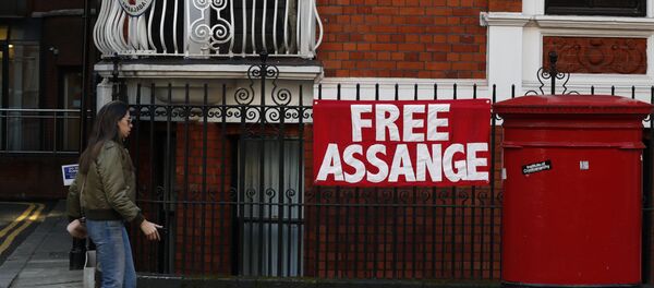 Жена пролази поред знака Ослободите Асанжа на згради амбасаде Еквадора у Лондону - Sputnik Србија