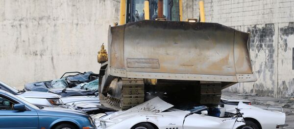 Булдожер уништава заплењене аутомбиле на паркингу Булдожер уништава заплењене аутомбиле на паркингу - Sputnik Србија