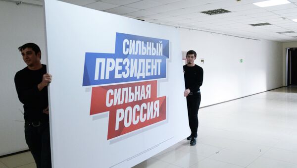 Radnici nose plakat u predizborni štab aktuelnog predsednika Rusije Vladimira Putina - Sputnik Srbija
