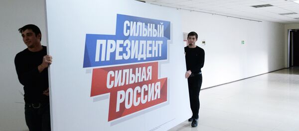 Радници носе плакат у предизборни штаб актуелног председника Русије Владимира Путина - Sputnik Србија