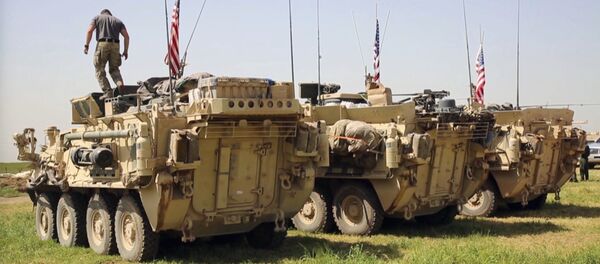 Амерички војник стоји на оклопном возилу у селу Дарбасија у Сирији Амерички војник стоји на оклопном возилу у селу Дарбасија у Сирији - Sputnik Србија