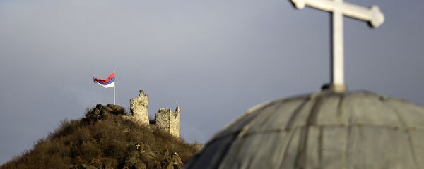 Српска застава поред остатака средњевековног града и Црква Светог Ђорђа у Северној Митровици - Sputnik Србија