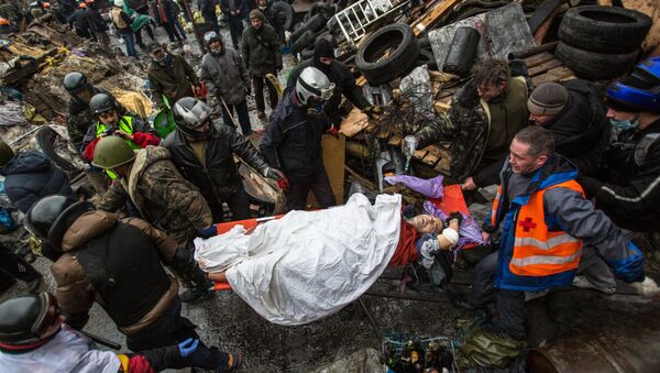 Pristalice opozicije nose ranjenika tokom sukoba demonstranata i pripadnika policije na Trgu nezavisnosti u Kijevu 20. februara 2017. - Sputnik Srbija