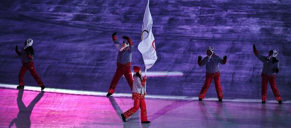 Volonter nosi olimpijsku zastavu pod kojom nastupaju ruski sportisti na Olimpijskim igrama u Pjongčangu 2018. - Sputnik Srbija