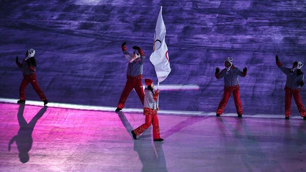 Волонтер носи олимпијску заставу под којом наступају руски спортисти на Олимпијским играма у Пјонгчангу 2018. - Sputnik Србија